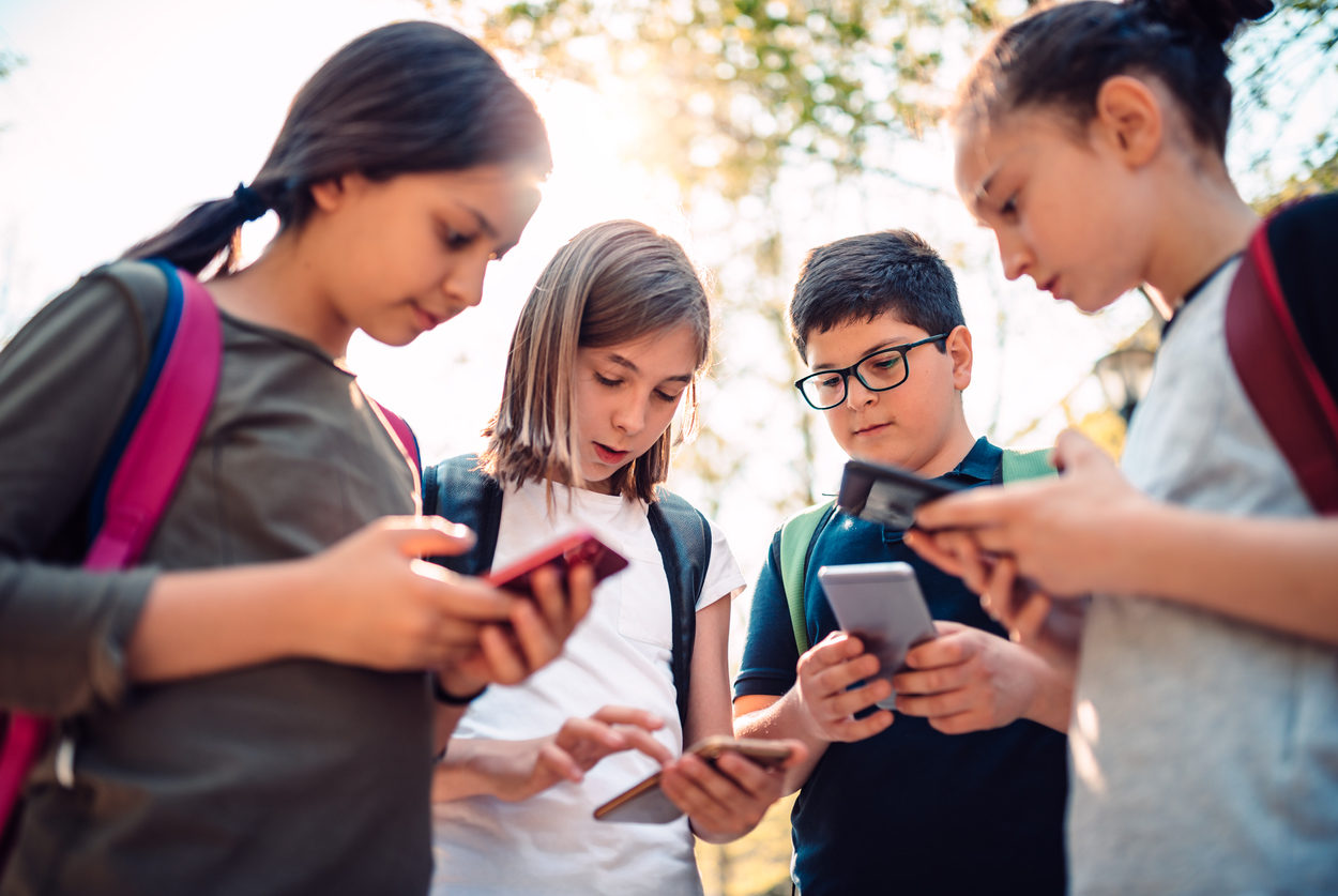 Kids playing video games on smart phone after school