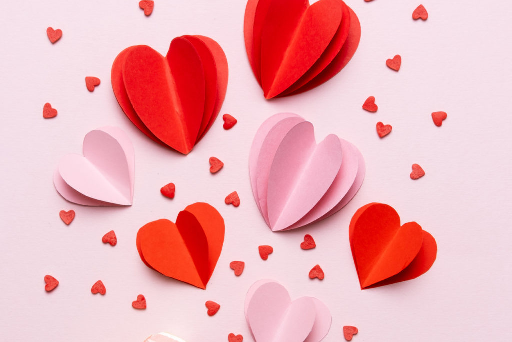 Valentine day composition with gift box and red hearts, photo template on pink background.