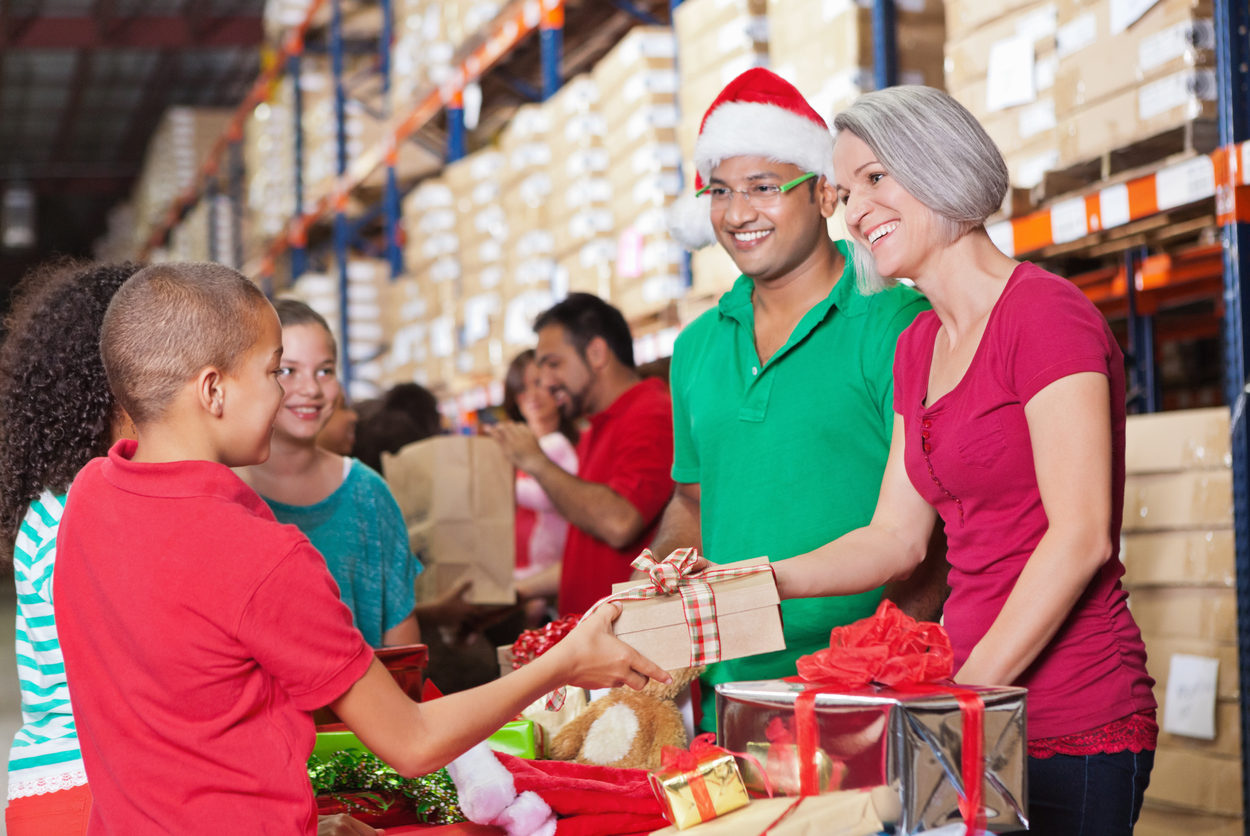 Adults and children volunteering at Christmas charity toy donation drive